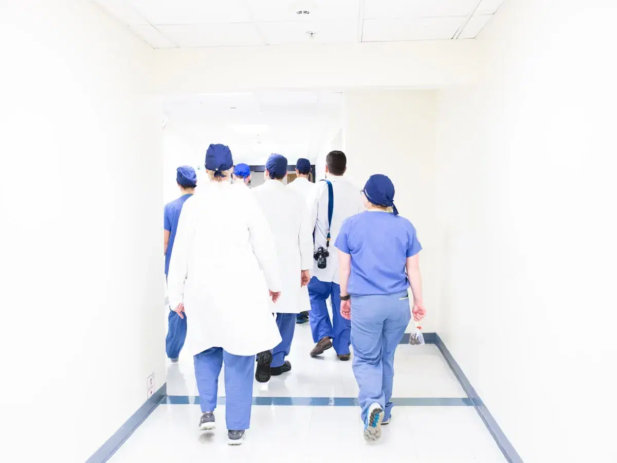 Medical students and staff walking through a teaching hospital corridor